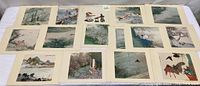 Photo showing the assortment of 15 Japanese wood block lithographs laid out flat for overview