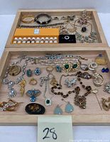 Full display of costume jewelry pieces arranged on two wooden trays alongside the perfume set with earrings, rings, necklaces, bracelets, and brooches.