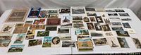 Wide view of collection spread out including numerous old photos, postcards, papers and currency.