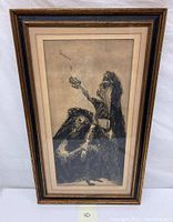 Full view of framed black and white vintage etching showing two figures, one tossing projectile, under glass and mounted on matting in decorative wood frame.