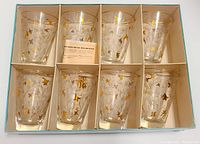 Full set of 8 glasses in original box showing gold and bronze floral designs and gold rims.