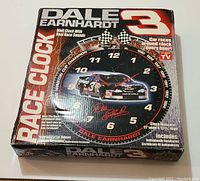 Clock inside original box showing graphic of Dale Earnhardt No. 3 race car and the phrase 'Race Clock' prominently on the box, box shows wear.