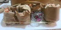 Glasses and metal caddy with one glass unwrapped showing grape design