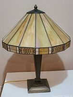 Full view of the bronze table lamp with stained glass shade showing color and structure
