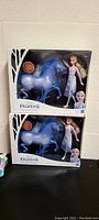 Photo of two boxed Frozen 2 Elsa doll sets showing the Elsa doll and blue spirit horse figure in original packaging with Frozen 2 branding.
