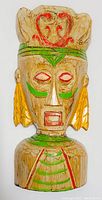 Front view of wooden tiki face wall hanger showing detailed red, green, and yellow paint accents.