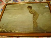 Full view of framed print depicting a nude young woman standing in shallow water, signed by artist Paul Chabas.