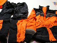 Full view of the rain jacket and pants showing the color scheme and logo details.