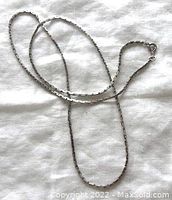 Full view of the long vintage sterling silver chain necklace laid out to show length and design, including the spring ring clasp.