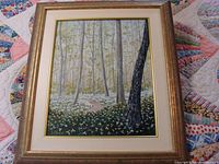 Full view of framed oil painting showing forest scene with pathway and flowers.