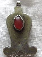 Front view of handmade silver pendant with oval carnelian stone centered on front surface.