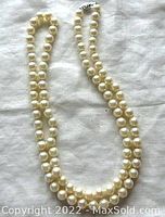 Full view of the pearl necklace laid out to show length and form
