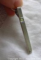 Side view of sterling silver modernist pendant showing the square light blue faceted stone set into the pendant and marked 925.