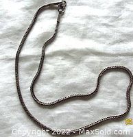Full length photo of the sterling silver men's necklace chain laid out on fabric.