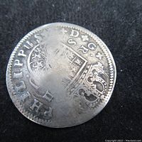 Obverse side of the 1722 Spanish silver coin showing a crowned shield with partial inscriptions.