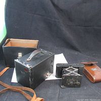 Overview showing two cameras and their cases on a black cloth background.
