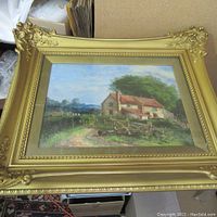 Full view of the framed oil painting showing the cottage scene and ornate gold frame.