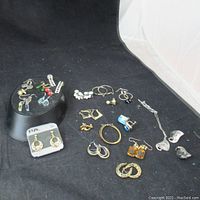 Full lot of assorted vintage costume jewelry including various pairs of earrings and a pendant necklace.