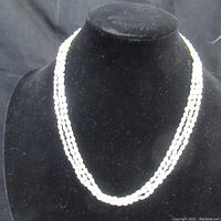 Front view of the double-strand white pearl necklace displayed on black velvet; shows the overall length and pearl arrangement.