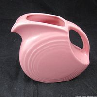 Side view of pink Fiesta Ware vintage pitcher highlighting the design and shape.