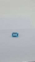 Single emerald-cut blue gemstone centered on white background