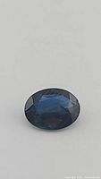 Oval cut blue sapphire gemstone viewed from top, facets visible