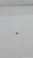 Oval cut bubble gum pink tourmaline gemstone on white background, showing color and size from top and side views.