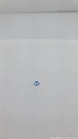 Oval cut lagoon blue Swiss blue topaz gemstone lying flat on white background