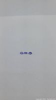 Three small oval cut blue-purple tanzanite gemstones arranged in a horizontal row on a plain light background.