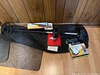 Wide view of metal detector, carrying case, pinpointer box, pouch, manual, and trowel