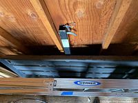 Overall view of the flat bed hitch carrier positioned on a wooden shed ceiling with visible ribs and hitch arm showing the MaxSold tag.