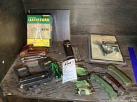 Overview of all tools and knives in the lot showing Leatherman, Cabela's multi tools, Mountain Quest multi tool, Buck folding pocket cutters, and Inox knife.