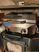 Front view of Nexgrill stainless steel gas grill showing dual control knobs, handle, and logo.