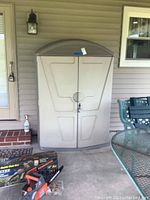 Front view of beige outdoor plastic storage cabinet with closed double doors, lock attached.