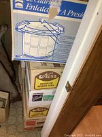 Boxes of pressure canner and mason jars stacked, showing brands Mirro and Kerr.