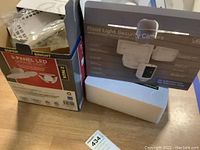 Photo of the boxed 3-panel LED garage lights and flood light security camera showing packaging and product details