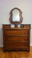 Front view of the antique walnut dresser with swivel mirror and two small top drawers showing overall condition.