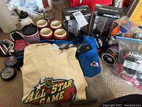 Photo showing various items including fleece pullover, T-shirt, stemware sets, collectible bear figures, and mugs all grouped together on floor.