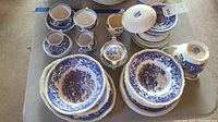Overhead view of assorted blue and white transferware pieces including cups, saucers, plates, sugar bowl