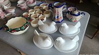 Wide view of all items including Japanese tea set, holly punch bowl, punch cups, and 4 milk glass hen dishes