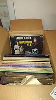 Box of vintage vinyl records showing Jeannie C. Riley - Harper Valley P.T.A. album at front