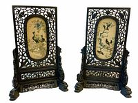 Pair of carved hardwood table screens showing front embroidered panels and bases