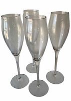 Four clear Cartier champagne glasses grouped together on a white background showing shape and size