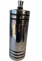 Front view of tall chrome cocktail shaker with Art Deco lines and black bands near base and top.