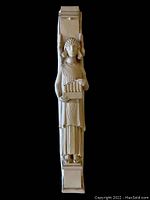 Full view of the chalkware angel figure with organ, off-white color on a black background.