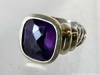 Close-up image showcasing the faceted square purple stone set in 14K gold bezel with sterling silver twisted band.