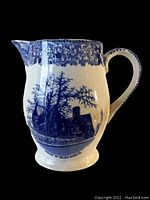 Front and side view of the blue and white transfer ware pitcher showing scenic House of Seven Gables design with floral decorations near the rim and handle.