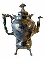 Front view of the tall Art Nouveau silver plated teapot showing detailed engraving and ornamental feet and handle.