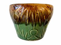 Side view of the brown and green glazed Ransbottom majolica pot planter with floral and grass embossed pattern.