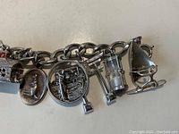 Close-up view of the sailboat charm and other nearby charms on the bracelet showing detail and condition.